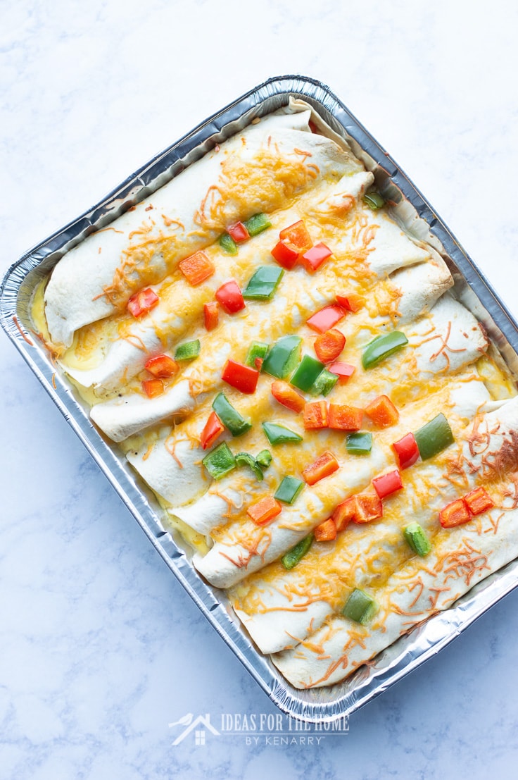 Red and green peppers on top of breakfast enchiladas made with eggs, ham and cheese for Christmas morning
