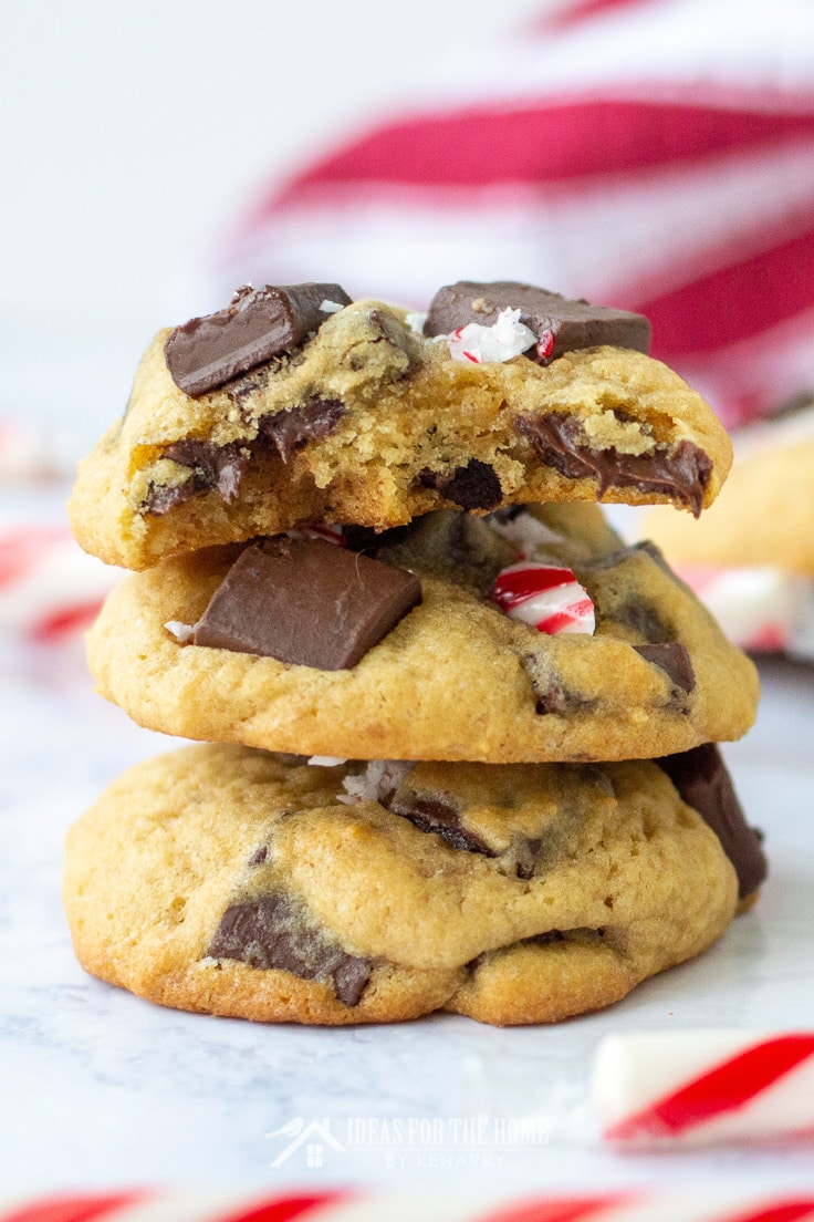 Close up on a stack of three chocolate peppermint cookies. The top cookie in the stack has a large bite out if it.