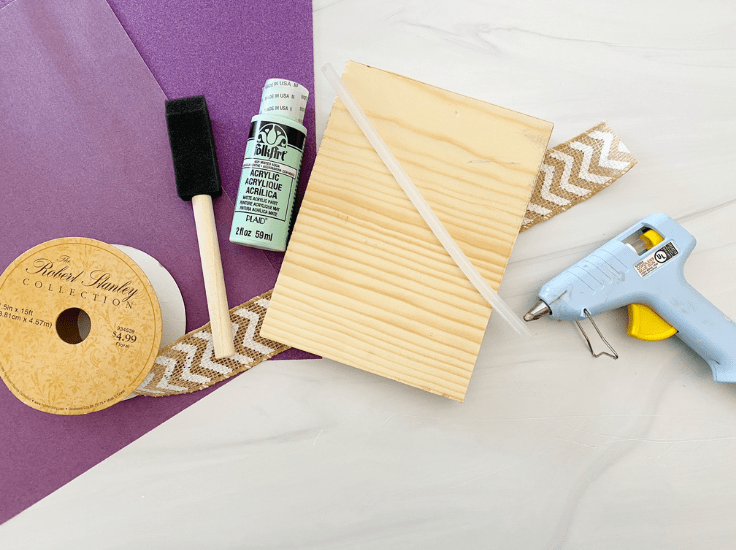 A wood block, hot glue gun, burlap ribbon, paint and a sponge brush.